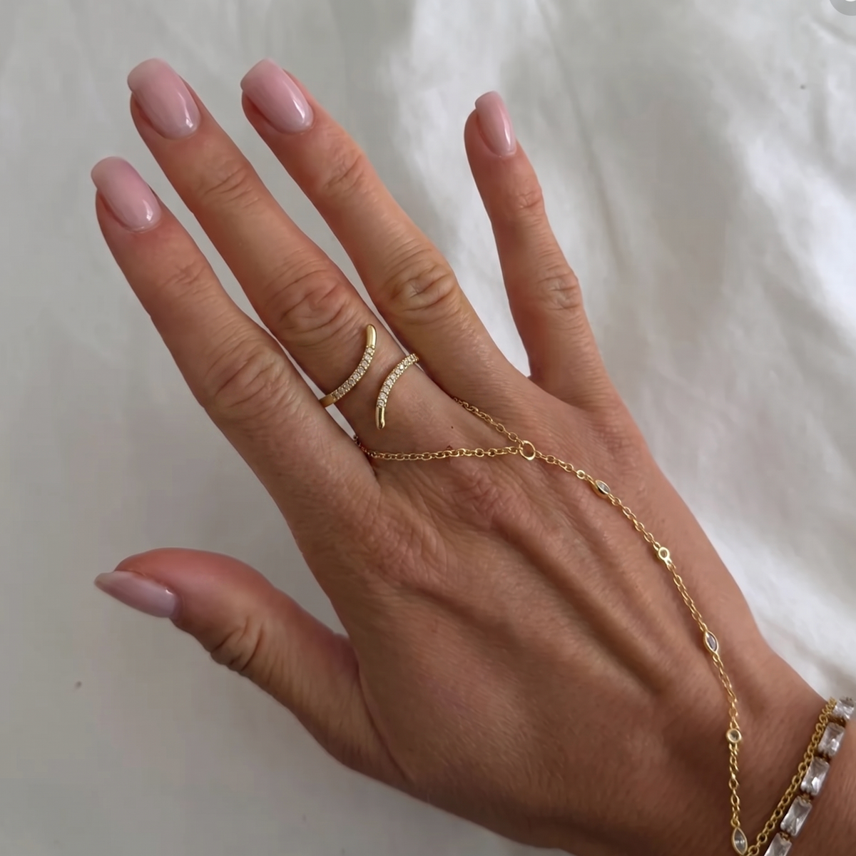 Gold spiral ring with embedded stones from İrva Collection featuring intricate design and sparkling accents.