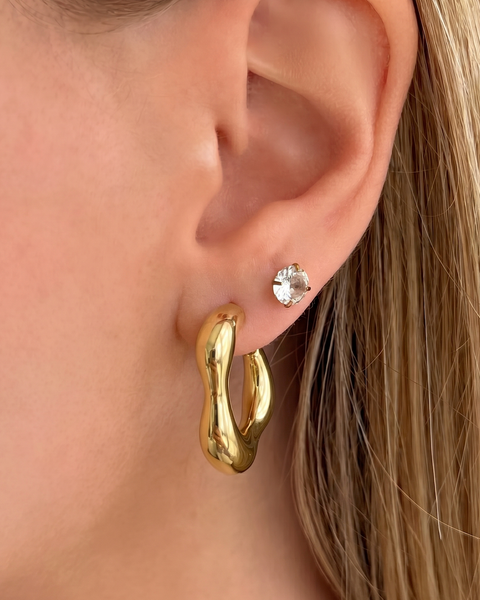 Gold Huggie earrings from İrva Collection featuring small, sleek hoop design with polished finish.
