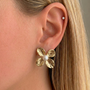 İrva Collection Sage Küpe with intricate gold-toned design, showcasing elegant dangle earrings on a neutral background.