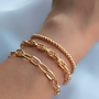 Three stylish İrva Collection bracelet sets featuring elegant designs with beads and charms, perfect for accessorizing.