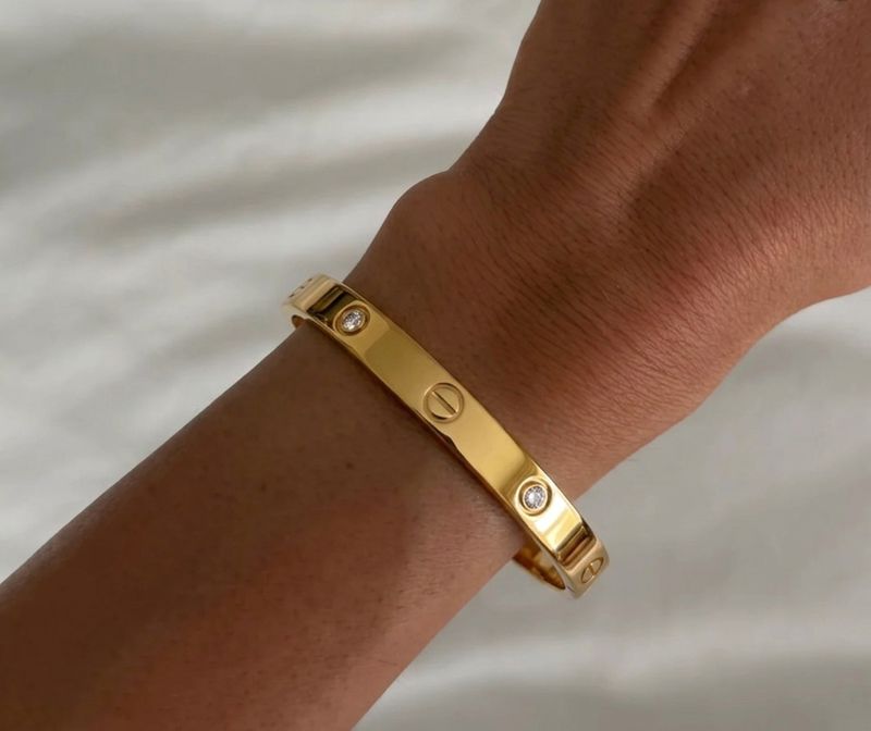 İrva Collection CRT Love Bileklik featuring a delicate bracelet with love-themed charms on a neutral background.