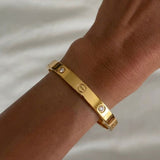 İrva Collection CRT Love Bileklik featuring a delicate bracelet with love-themed charms on a neutral background.