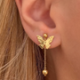 İrva Collection sallantılı kelebek küpe with dangling butterfly design, gold-tone metal, and intricate detailing.