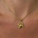 Gold Yengeç Kolye from İrva Collection featuring a detailed crab pendant on a delicate chain.