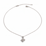 Çelik minimal altın kaplama yonca kolye from İrva Collection with delicate pendant on a chain, close-up of jewelry.