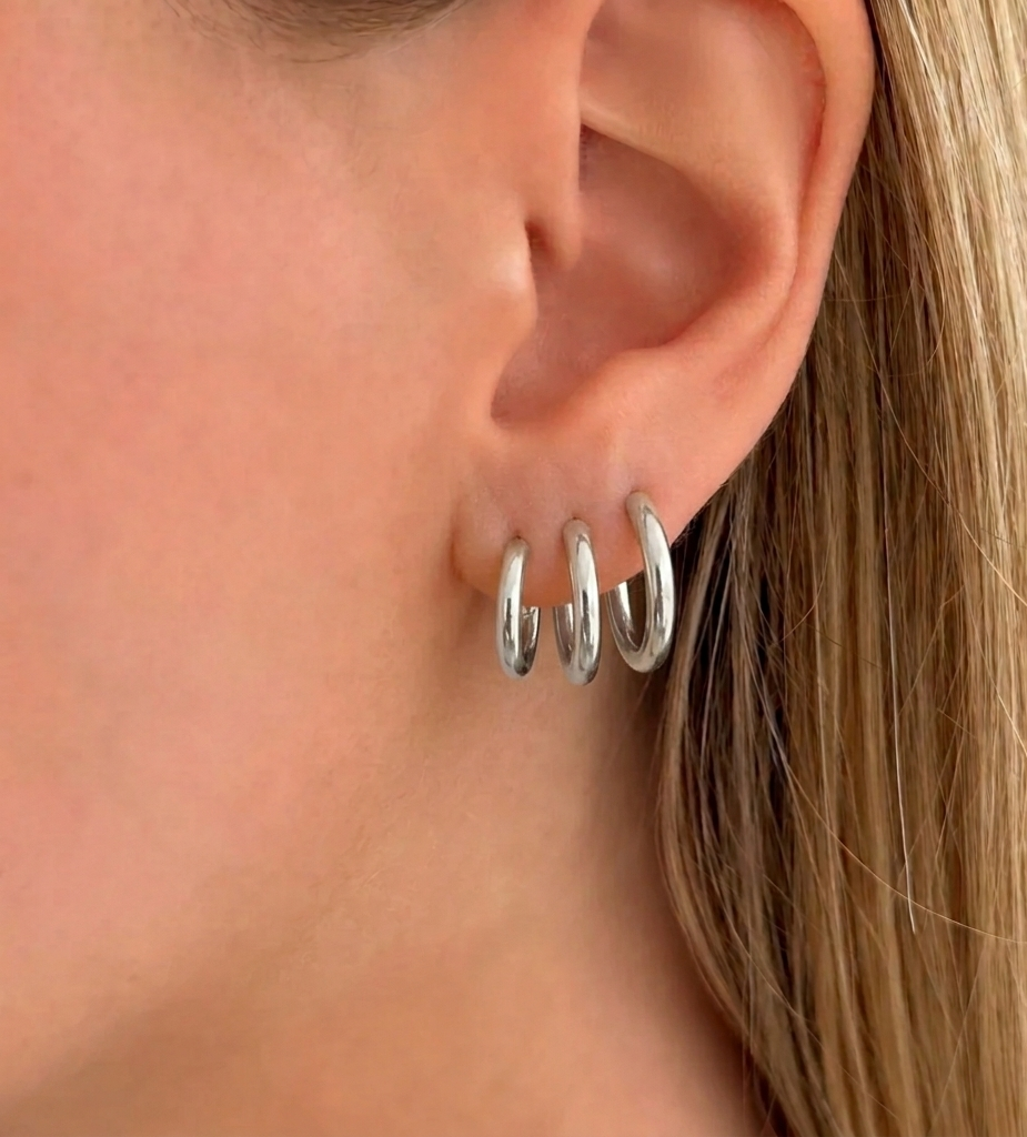 Set of three silver hoop earrings from İrva Collection featuring classic round designs on a white background.