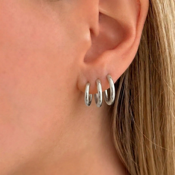 Set of three silver hoop earrings from İrva Collection featuring classic round designs on a white background.