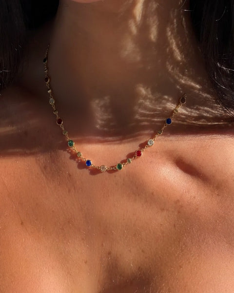 Colorful gemstone necklace from İrva Collection featuring vibrant stones and intricate design, displayed on a neutral background.