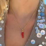İrva Collection Viral Biber Kolye, a vibrant red pepper pendant necklace with intricate detailing and a gold chain.