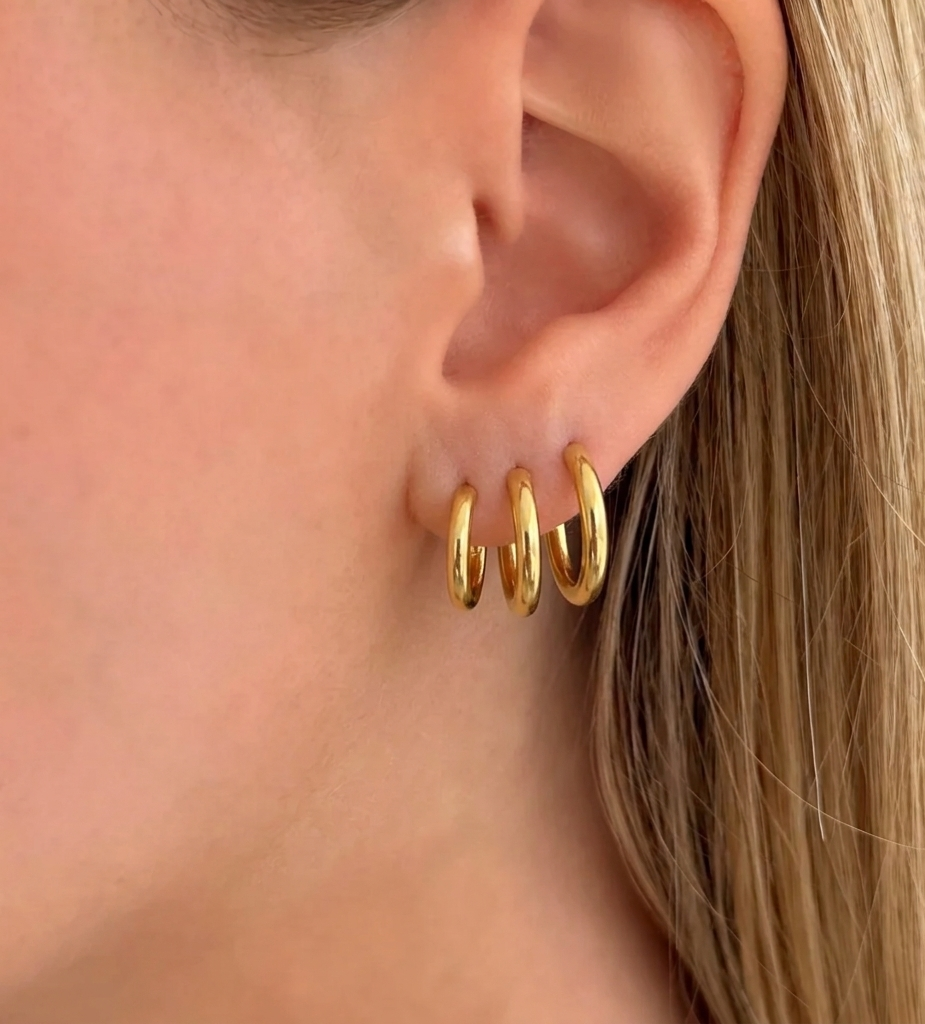 Set of three gold hoop earrings from İrva Collection, featuring classic circular design in a stylish jewelry set.