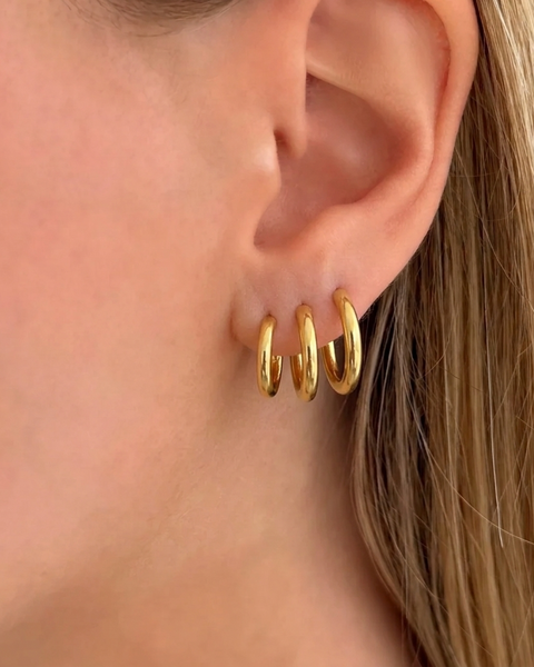 Set of three gold hoop earrings from İrva Collection, featuring classic circular design in a stylish jewelry set.