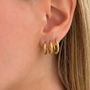 Set of three gold hoop earrings from İrva Collection, featuring classic circular design in a stylish jewelry set.