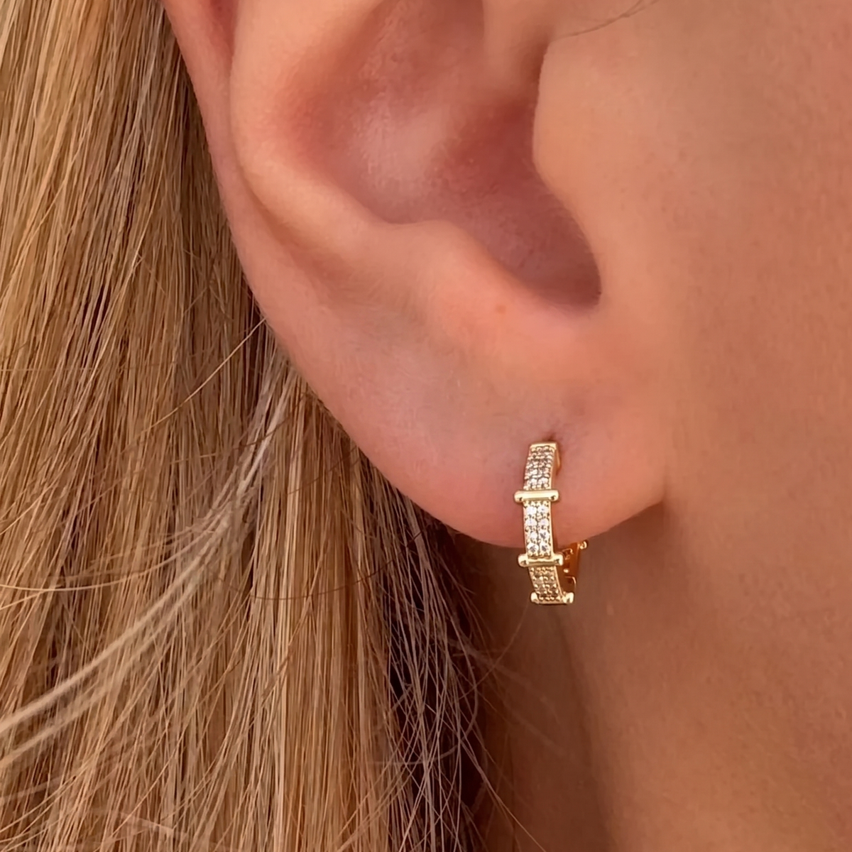 Gold Gemini-shaped earrings from İrva Collection featuring sleek, modern design inspired by Serenay Sarıkaya style.