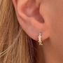 Gold Gemini-shaped earrings from İrva Collection featuring sleek, modern design inspired by Serenay Sarıkaya style.